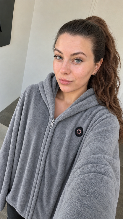Frau trägt die graue Wärmolo Heizdecke zu Hause