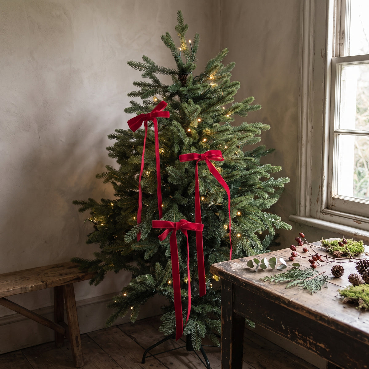Red velvet bows with long tails on a Christmas tree