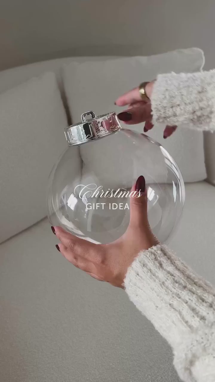 Filling a clear round fillable ornament with gifts